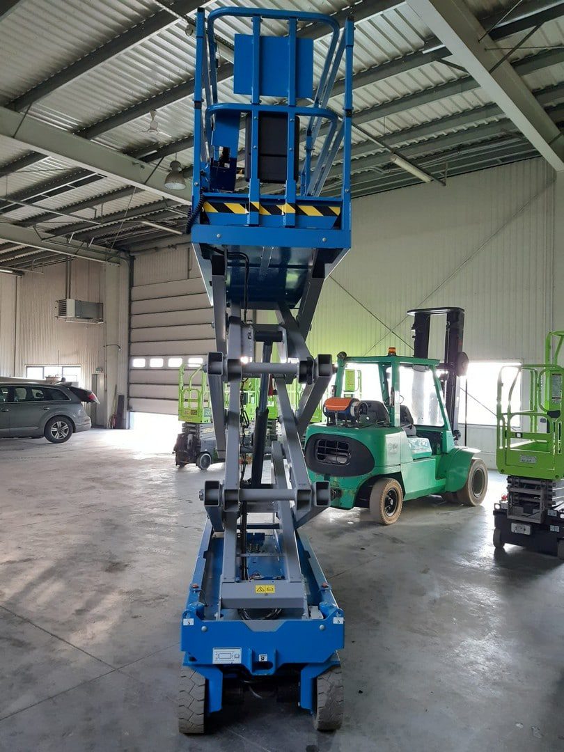 Niebieska podnośnikowa platforma w magazynie.