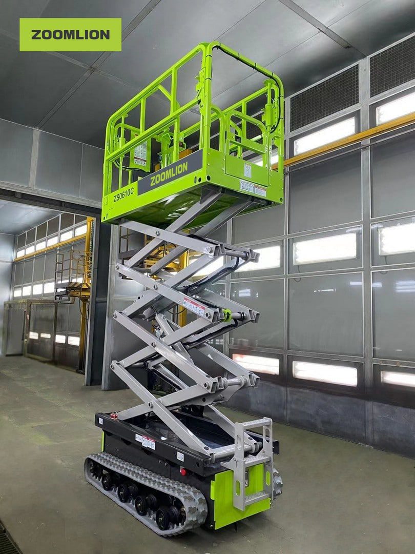 Zielona podnośnik nożycowy gąsienicowy Zoomlion w magazynie.