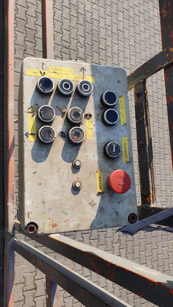 Panel sterowania maszyną z przyciskami i dżojstikami.