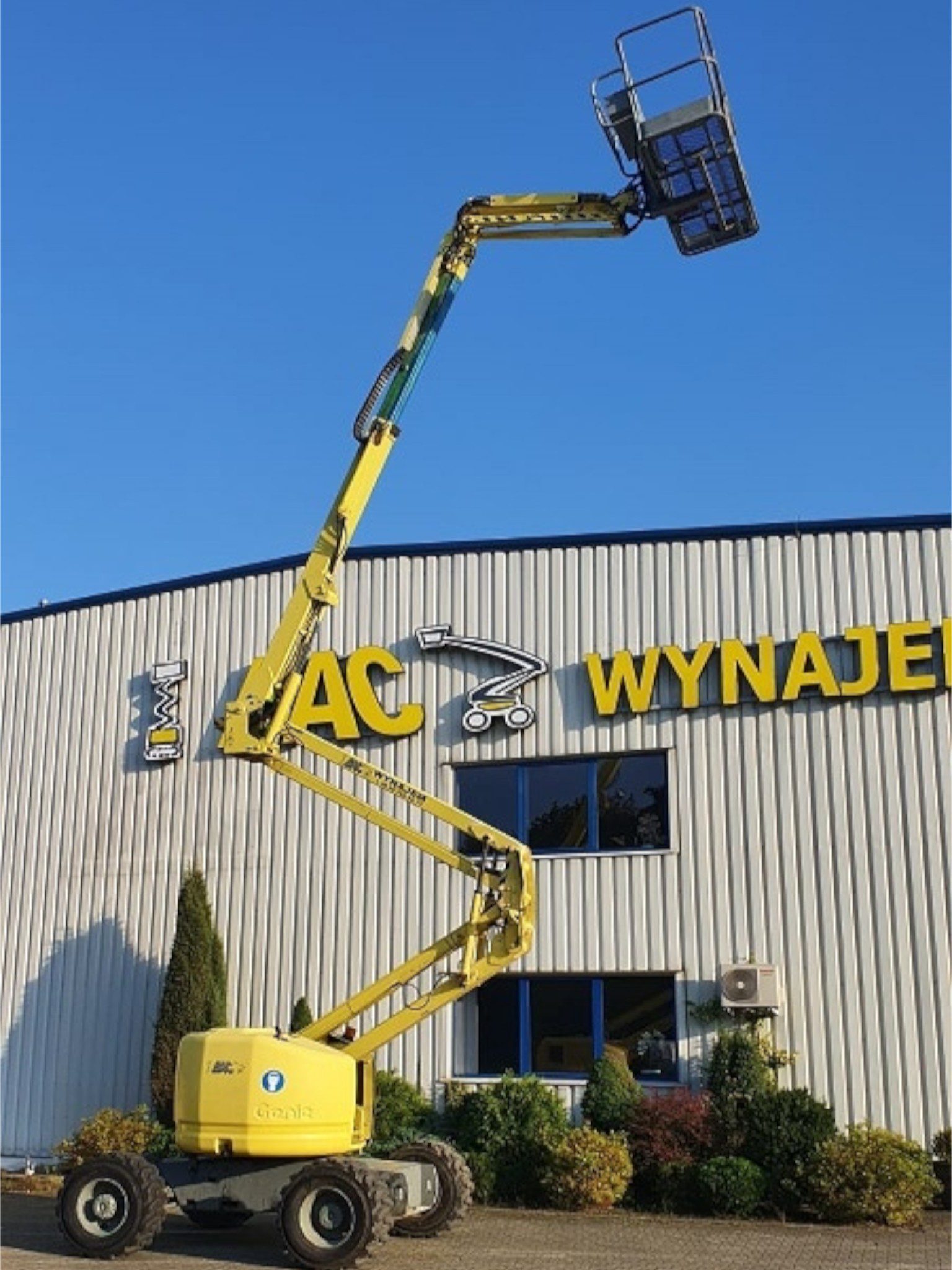 Podnośnik koszowy żółty przed budynkiem BAC Polska