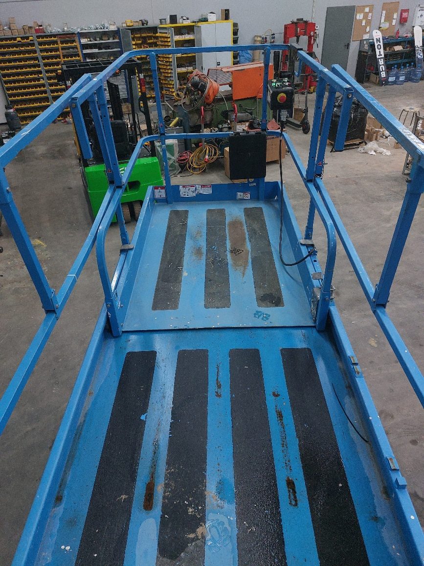 20230127_161027_resized Pracownik na platformie podnośnikowej w warsztacie.