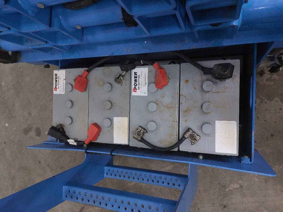 Akumulator na wózku paletowym w magazynie