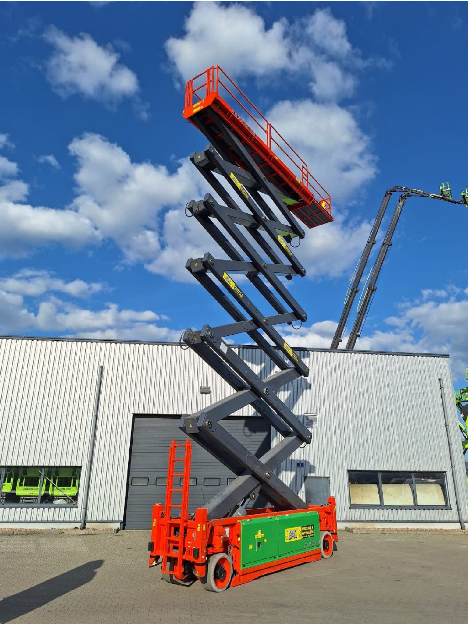 Podnośnik nożycowy Dingli JCPT 3214 DC w trakcie pracy – elektryczny model z maksymalną wysokością roboczą 32 metry, przeznaczony do zadań wymagających dużego zasięgu pionowego, dostępny w ofercie wynajmu Bac Polska.