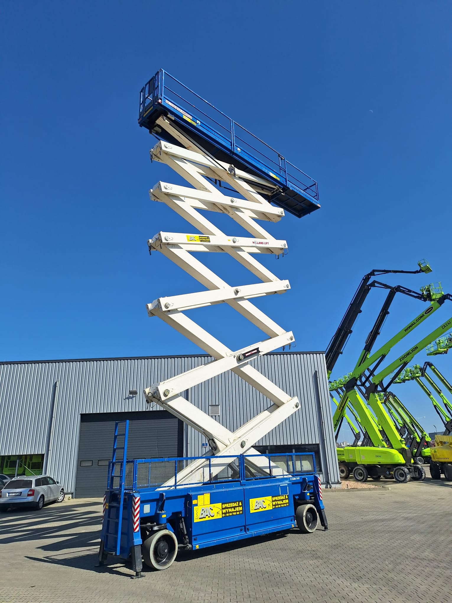 Podnośnik elektryczny nożycowy Holland Lift HL-330 E14 na wynajem w Bac Polska – kompaktowy, cichy, do pracy na wysokości do 33 m.