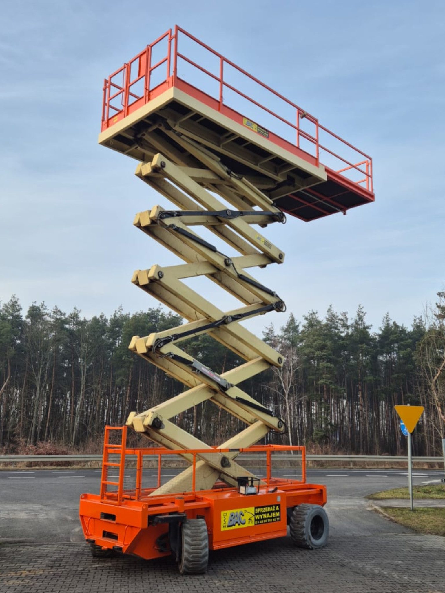 Podnośnik elektryczny Holland Lift HL-195 EL25 – cicha zwyżka nożycowa o wysokości roboczej 21,4 m, kompaktowa i bezpieczna, dostępna na wynajem w Bac Polska.