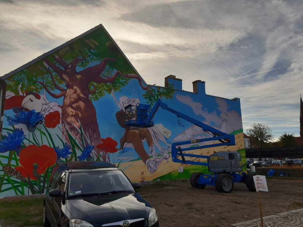 rozłożony podnośnik przegubowy wynajęty w bac polska podczas prac nad pierwszym muralem w rzepinie