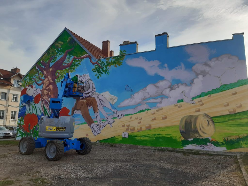 podnośnik przegubowy wynajęty w bac polska podczas prac nad pierwszym muralem w rzepinie