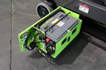 Зеленый аккумулятор с проводами для электромобиля.