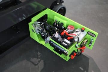 Hydraulický motor v otevřeném zeleném krytu.