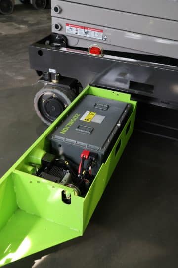 A truck battery mounted in a green box.