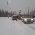 Cars in a winter traffic jam at a gas station.