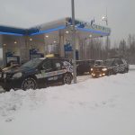 Samochody przy stacji paliw zimą.