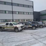 Rally cars in a winter setting in front of the building.