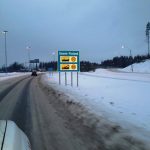 Straßenschild an der finnischen Grenze im Winter.