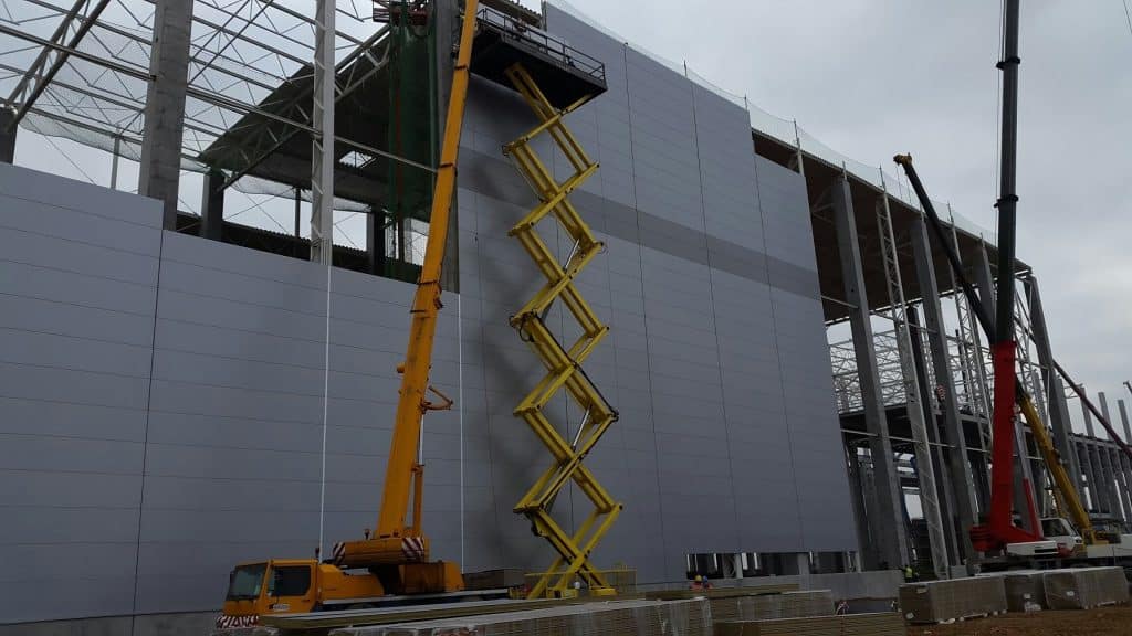 Installation of the facade at the stadium with a crane.