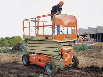 A worker on a scissor lift at a construction site.