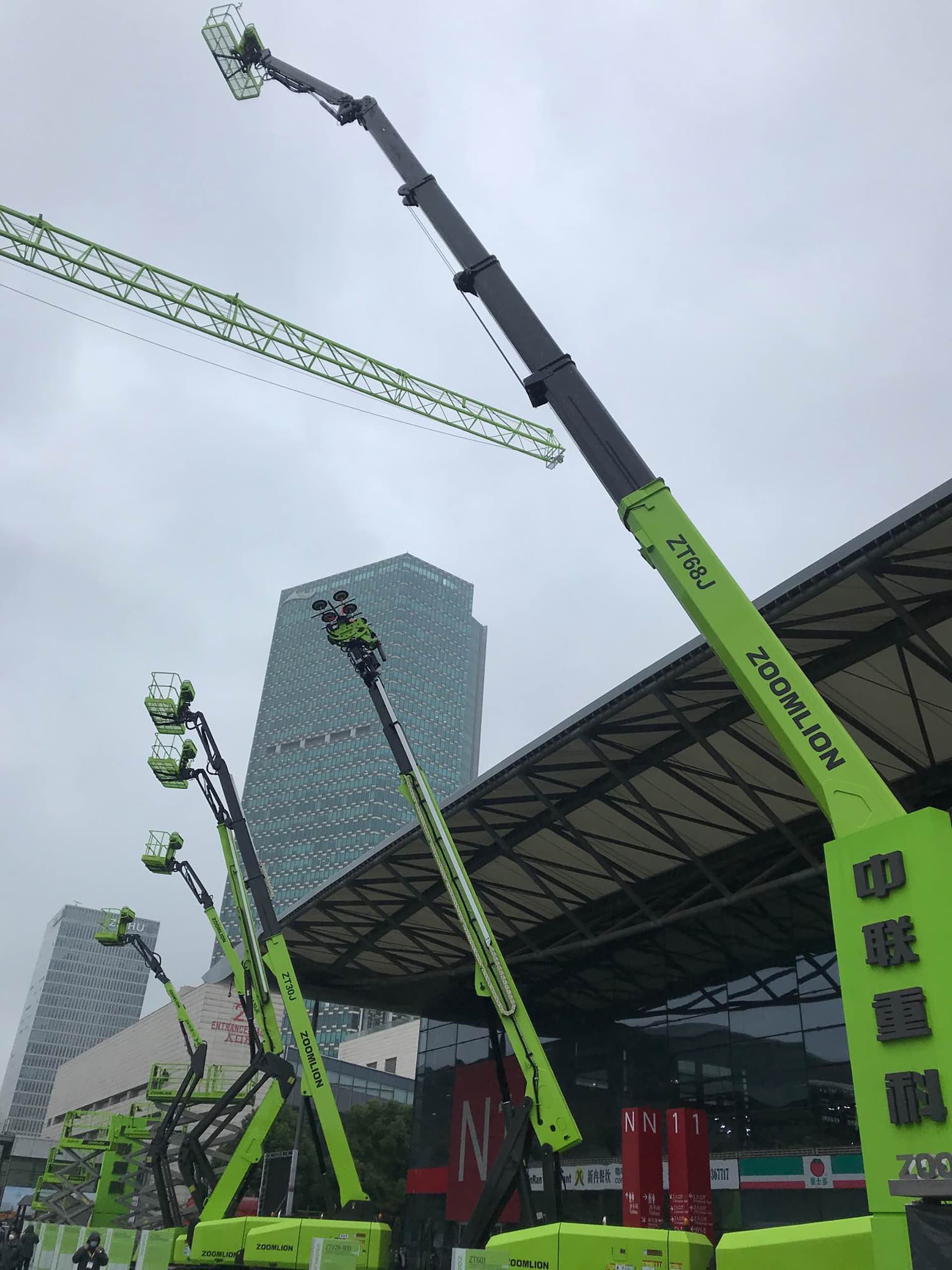 Kräne der Marke Zoomlion vor dem Gebäude.