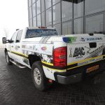 A car with a company advertisement parked in front of the building.