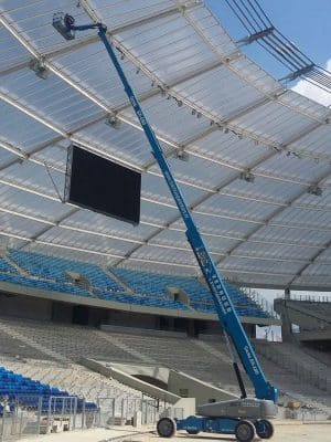 Dźwig na budowie stadionu instaluje oświetlenie.