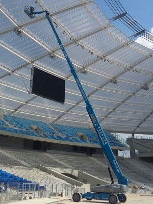 Ein Kran auf der Baustelle des Stadions installiert die Beleuchtung.