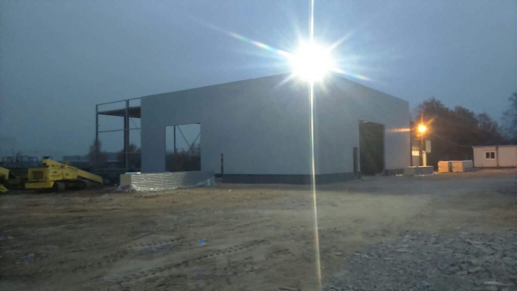 Construction of an industrial hall at dusk.