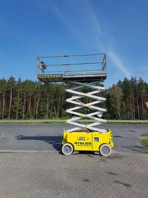 Ножичний підйомник біля дороги поруч з лісом.