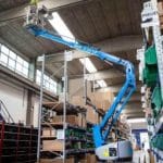 Worker on an aerial lift in a warehouse.