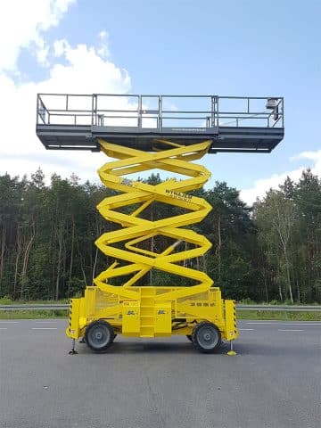 Yellow mobile scissor lift in the parking lot.