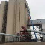 Przemysłowy silos i praca na podnośniku.