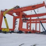 Big red container cranes in the port in winter.