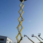 Yellow scissor lift extended upward.