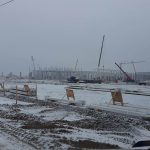 Stadium construction in winter, cranes, snow.