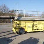 Yellow farm trailer in the parking lot.