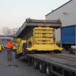 Loading construction equipment onto a truck trailer.