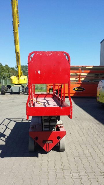 A red aerial lift on a construction site.