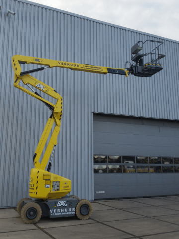 Scissor lift yellow by the building.