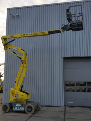 Scissor lift in front of an industrial building.