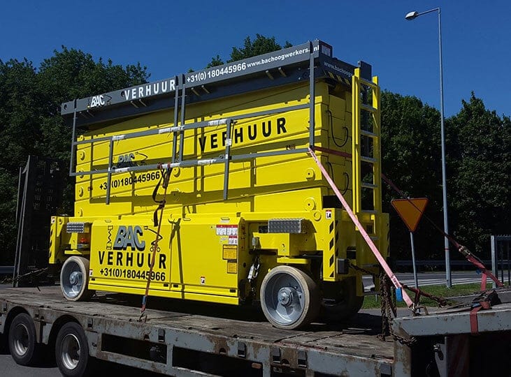 Yellow waste container on a truck trailer.