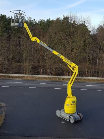 Yellow aerial lift on the road.