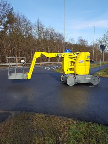 Yellow aerial lift on the road.