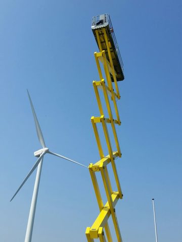 Aufzug und Windkraftanlage vor dem Himmel.