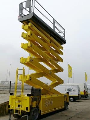 Yellow scissor lift on a construction site.