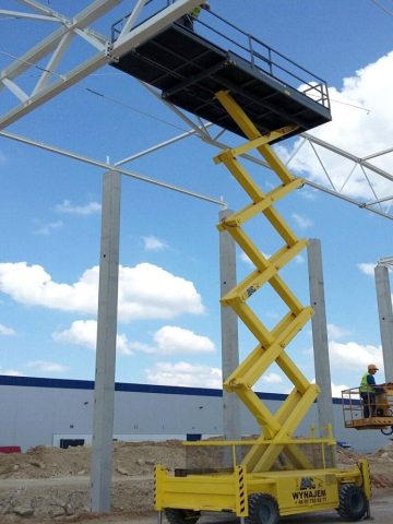 Scissor lift and steel structure on site.
