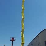 Yellow aerial lift at an industrial construction site.