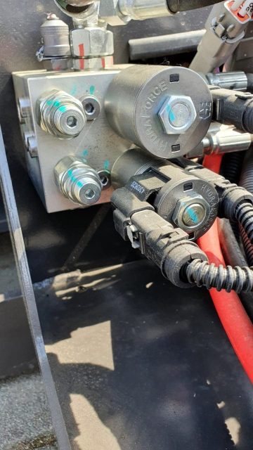 Hydraulische Kupplungen und Leitungen an der Maschine.