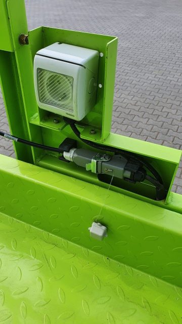 Green automatic gate opener in the parking lot.