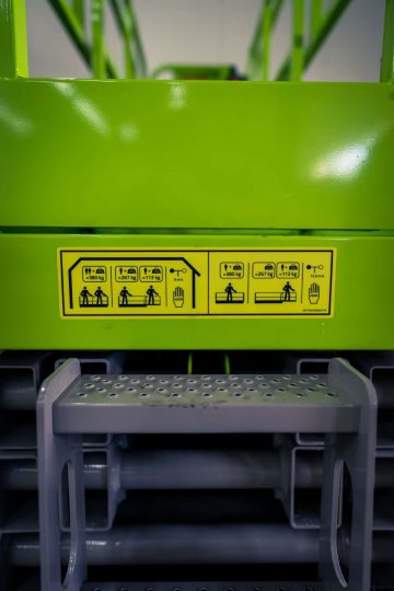 Safety sign on green industrial equipment.