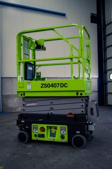 Scissor lift, green, in the industrial hall.