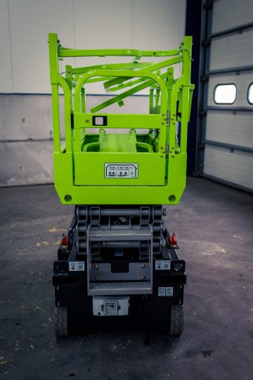 The back of a green forklift in a warehouse.