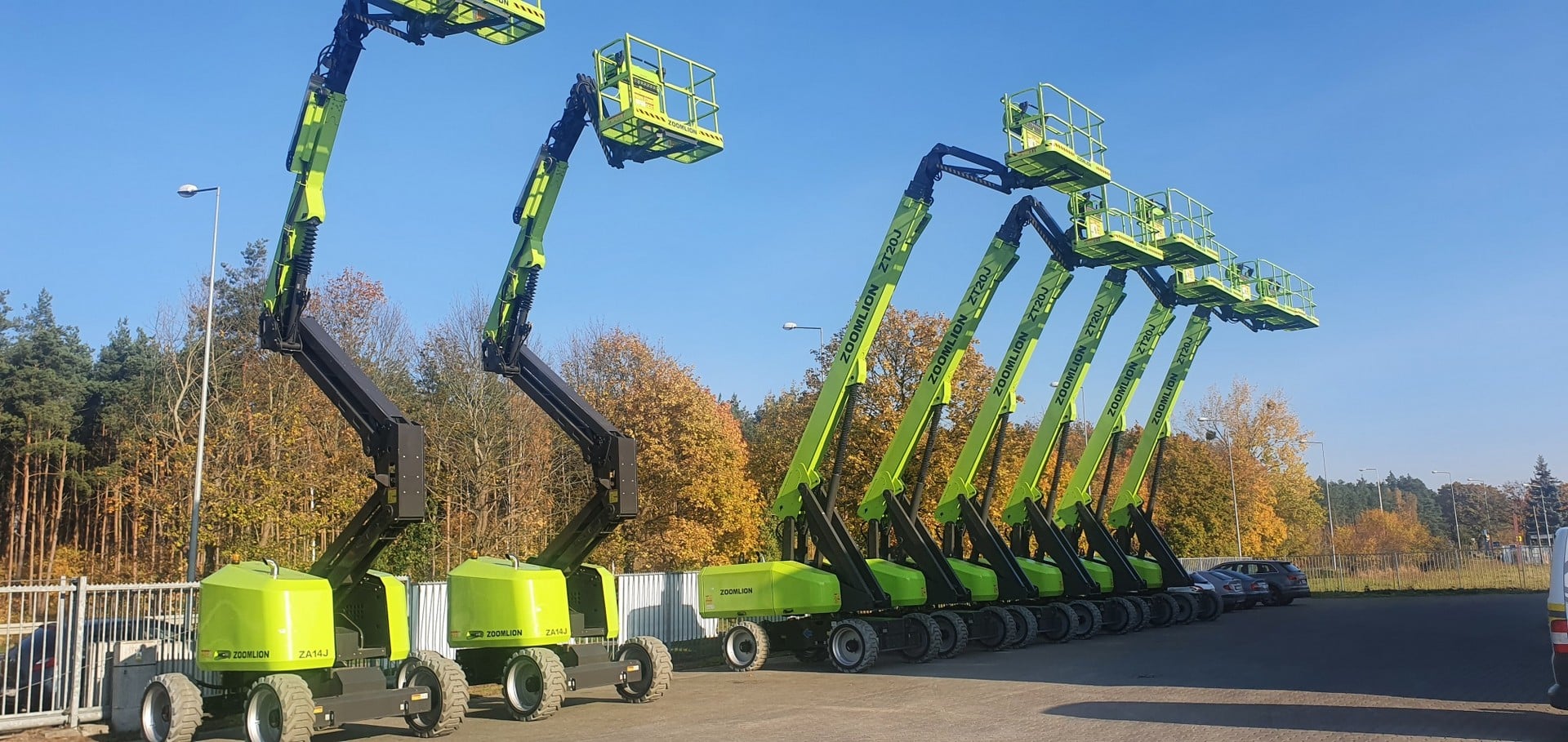 Rząd podnośników koszowych Zoomlion w parkingu.